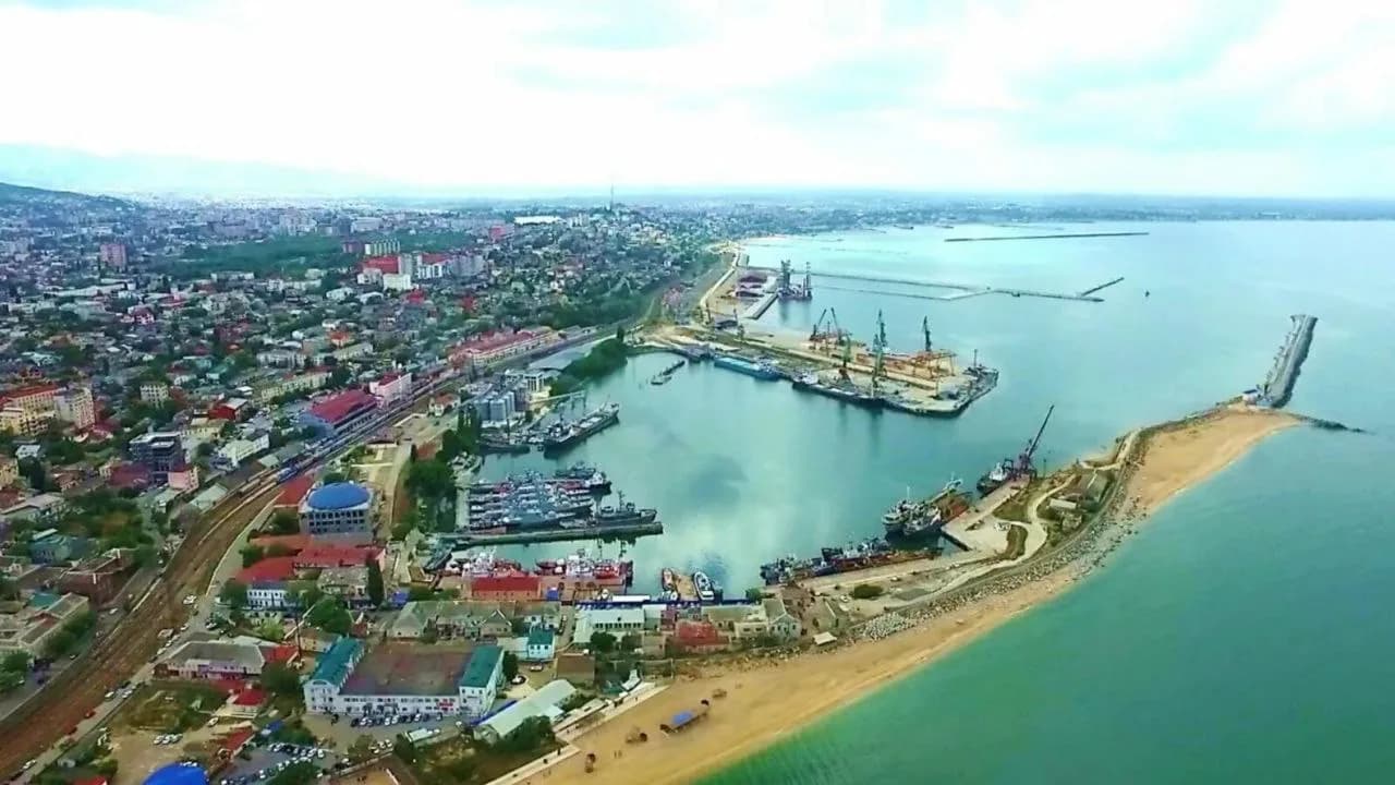 Вид сверху на гавань Махачкалинского морского торгового порта с портовыми кранами и молом