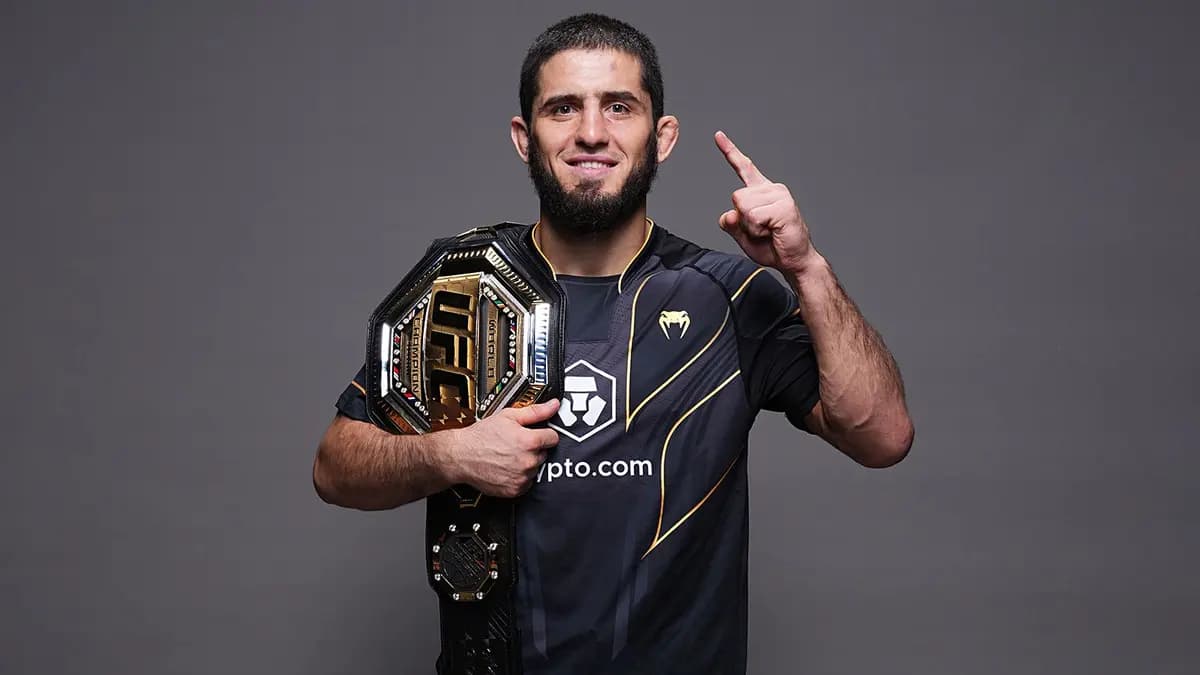 Боец с чемпионским поясом UFC поднимает палец вверх в знак победы
