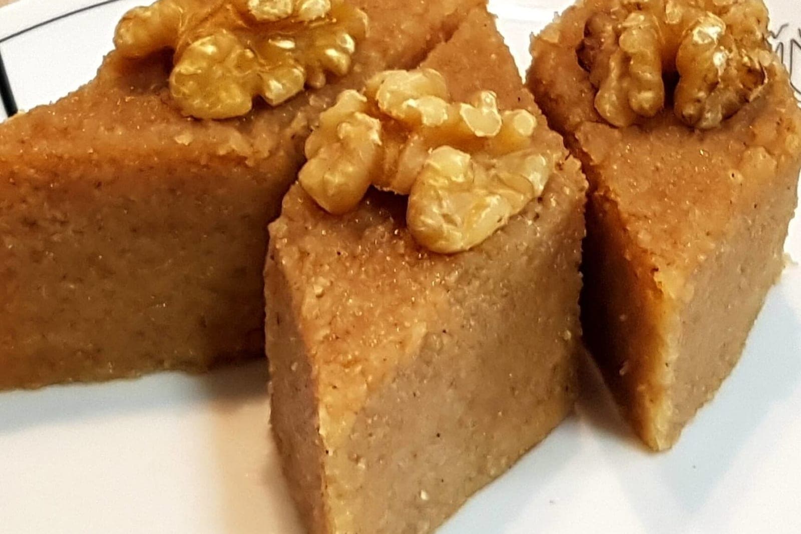 Кусочки бахуха, нарезанные ромбиками, украшенные половинками грецкого ореха, на тарелке