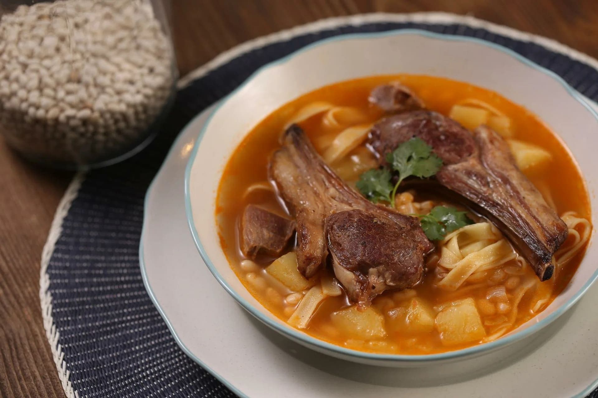 Бурчак-шурпа с фасолью, лапшой и рёбрышками в тарелке