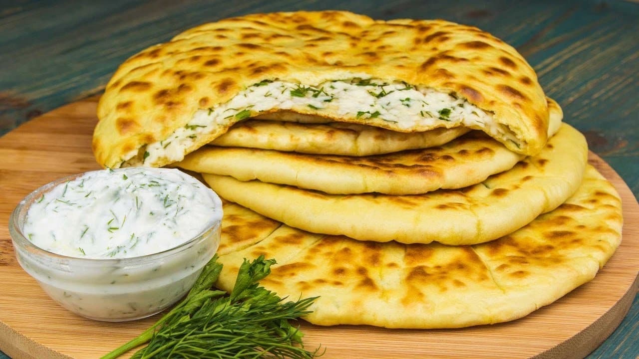 Хычин в разрезе с начинкой из сыра и зелени, соус рядом