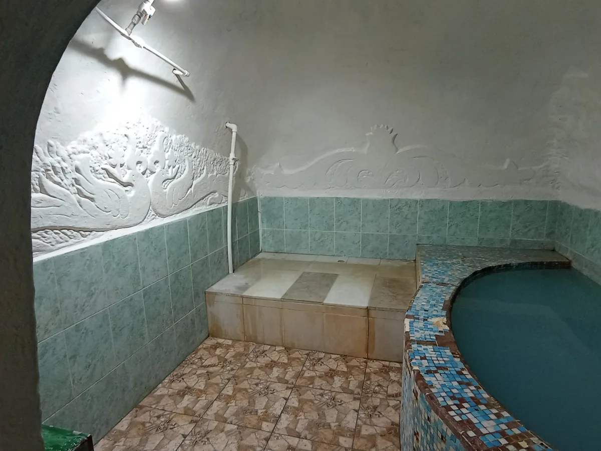 Круглая купель с минеральной водой в помещении со сводчатым потолком и лепниной на стенах