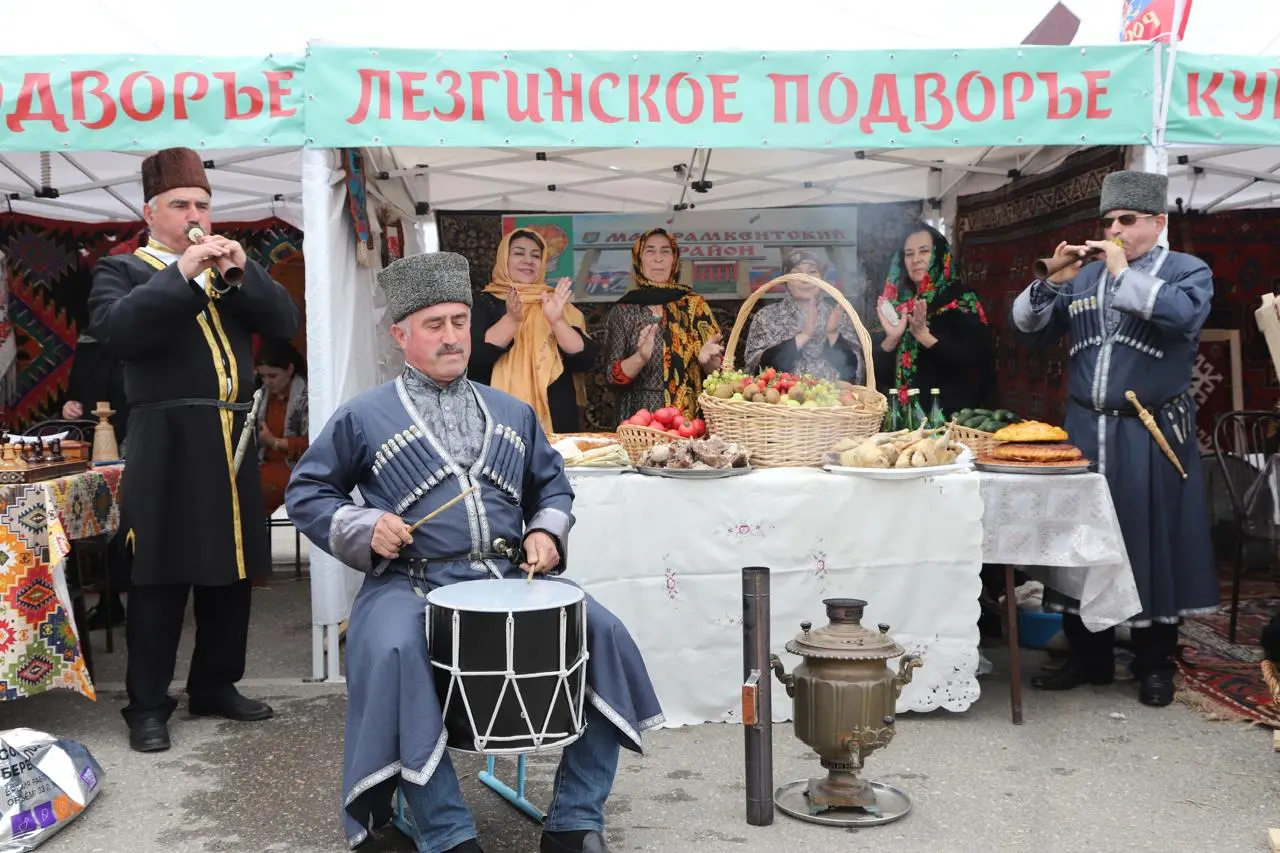 Народное подворье на выставке у «Анжи Арены» в Каспийске: музыканты в национальных костюмах и стол с угощениями